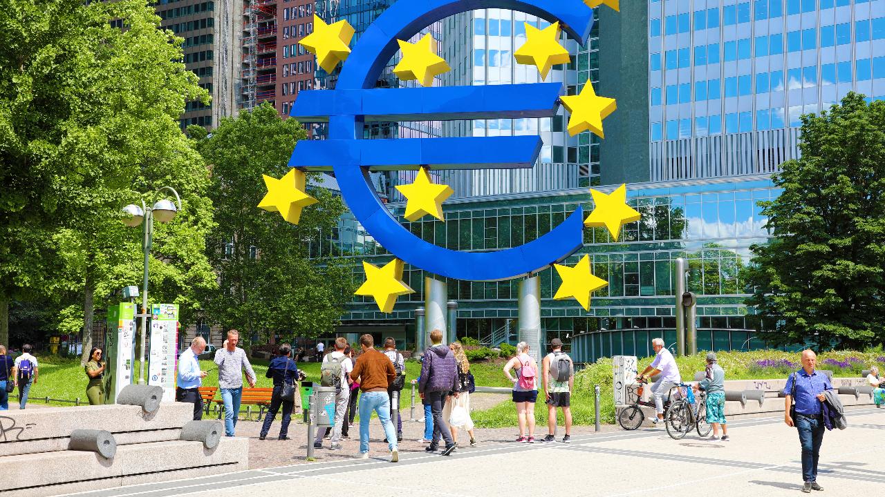 FRANCOFORTE, GERMANIA - 13 GIUGNO 2019: persone che camminano sotto il simbolo dell'euro a Francoforte. La Banca Centrale Europea amministra la politica monetaria della zona euro. La sede è a Francoforte, in Germania.